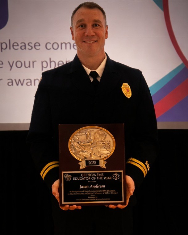 Captain Jason Anderson holds his Educator of the year award